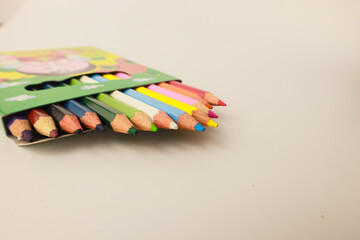 A top view image of multicolored pencil crayons on a white background.