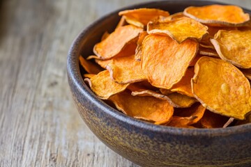 A bowl of homemade sweet potato chips, highlighting a healthy and crispy snack alternative to traditional potato chips. These delicious chips are rich in flavor and offer a nutritious option