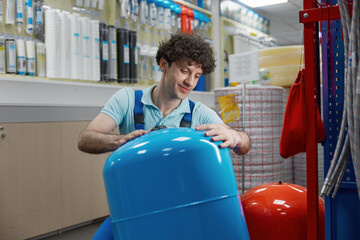 Portrait of plumber carrying hydraulic tank bought at plumbing shop