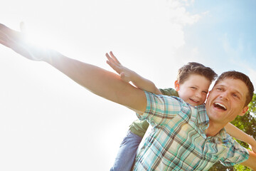 Dad, son and sky with fly on piggyback for fun, support and care outdoor in France. People, parent and smile with kid as family on break to play with love, trust and child development or growth