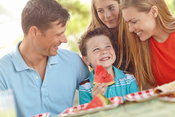 Family, happy and excited in nature for picnic, fun activity and watermelon for refreshing snack. Parents, children and favorite fruit in park for relationship development on vacation in Australia