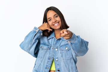 Young latin woman isolated on white background making phone gesture and pointing front