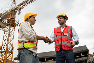 Asia engineer man worker hand shake with India engineer man with crane background 
