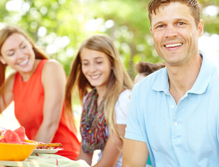 Portrait, family and bonding with dad, picnic and parents with siblings, nutrition or healthy in nature. Happy, woman and man with kids, vegan and fruit in weekend, fun and break in park and together