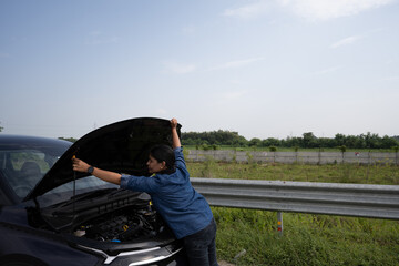 Young Indian girl on the road trying to fix her car after it's breakdown on road