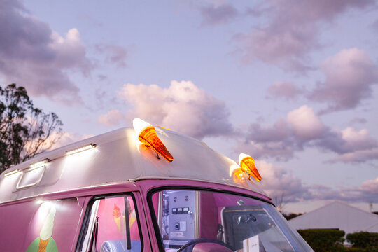 Pink Ice cream truck at dusk with pink clouds above selling ice-cream
