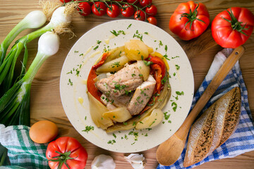 Baked mackerel with escalivada vegetables, peppers, onions and eggplant. Top view table with decoration.