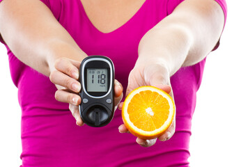 Hand of woman holding glucometer with result sugar level and fresh orange. Healthy nutrition during...