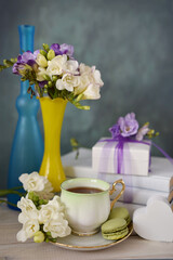 Tea with Freesia Flowers and Macarons in a Still Life Setting