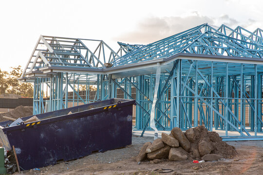 skip bin in front of a metal framed house getting built