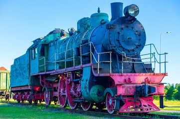 Naklejka premium Soviet-Era Diesel Locomotive in Rustic Setting. Historic Steam Locomotive on Display at a Train Station