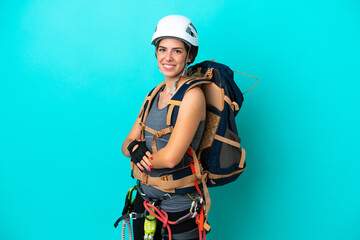 Young Italian rock-climber woman isolated on blue background with arms crossed and looking forward