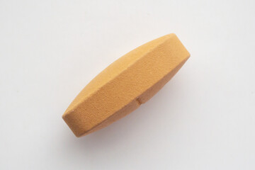 Orange vitamin pill tablet on white background
