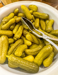 close up of Turkish style green pickle served as in a bowl with a metal tong. High quality photo