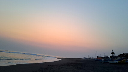 Yogyakarta, Indonesia - September 20 2024: People enjoying the pinkish sunset on the beach