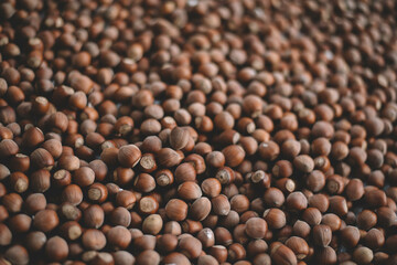 Hazelnuts in a wooden bowl on rustic background, Hazelnut background with green leaf