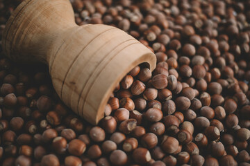 Hazelnuts in a wooden bowl on rustic background, Hazelnut background with green leaf
