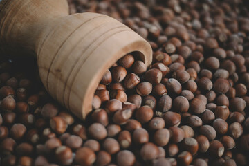 Hazelnuts in a wooden bowl on rustic background, Hazelnut background with green leaf