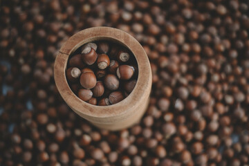 Hazelnuts in a wooden bowl on rustic background, Hazelnut background with green leaf
