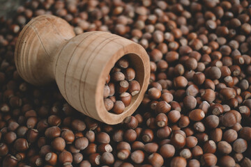 Hazelnuts in a wooden bowl on rustic background, Hazelnut background with green leaf
