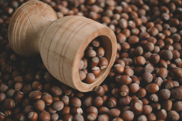 Hazelnuts in a wooden bowl on rustic background, Hazelnut background with green leaf
