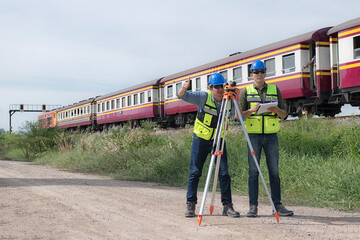 construction worker with helmet. Team surveyors  check  leveling of railway construction site.