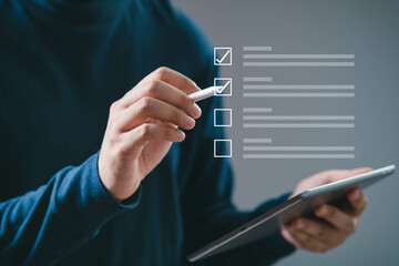 Person using a digital tablet to check items on a virtual checklist. Concept of productivity and...