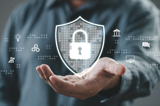 A person demonstrating digital security with a hand gesture, showcasing a lock icon on a shield in a technology-focused environment.