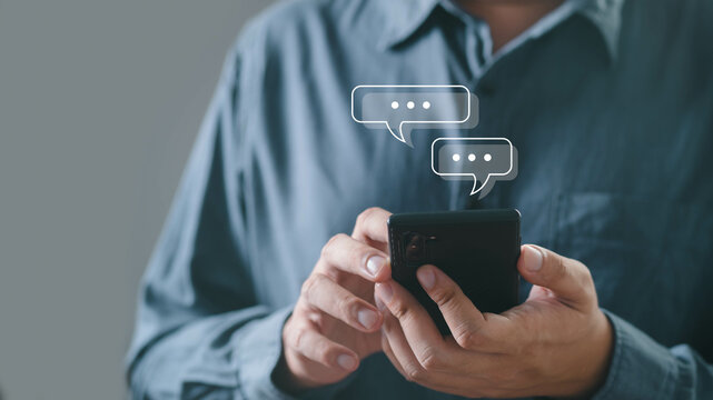 A person interacts with a smartphone, sending messages with speech bubbles indicating communication and connection in a modern context.