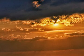 A view of a warm sunset illuminating the stormy clouds at dusk with vivid colors