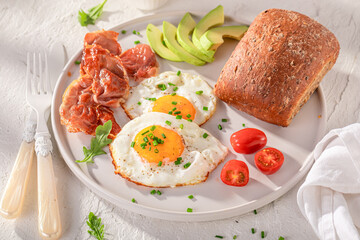 Fresh and tasty breakfast with egg, tomato and rolls.