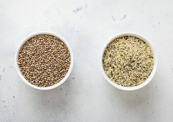 Ceramic bowls with green and white melted cannabis hemp seeds on kitchen table.Macro.