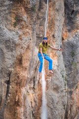 A tightrope walker walks along a cable stretched over a canyon.
