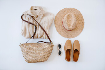 Bohemian Summer Flat Lay Featuring Woven Hat, Bag, Sunglasses and Earth-Toned Linen Shirt and Leather Accessories
