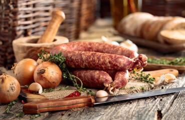 Dry-cured sausage with bread and spices on a old wooden table.