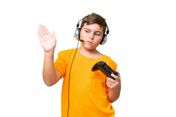 Little caucasian kid playing with a video game controller over isolated chroma key background making stop gesture and disappointed