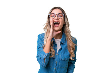 Young Uruguayan woman over isolated background shouting with mouth wide open