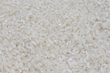 Dry Uncooked White Rice Background - Top View, Flat Lay. Scattered Raw Long Grain Rice. Asian Cuisine and Culture. Healthy Eating Ingredients. Diet Food
