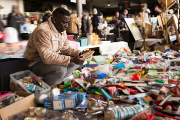  Man chooses antiques at a flea market
