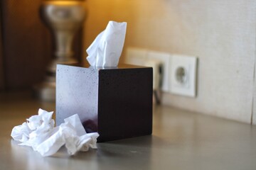 Used paper tissues and box on blurred background