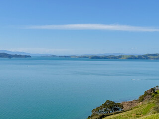 View of a park in New Zealand. Blue ocean and green grass field on spring day. Duder Park.