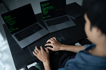 Asian man software engineer Working on Computer at office desk for writing program code IT Software Engineer finding errors tech support devops creating digital