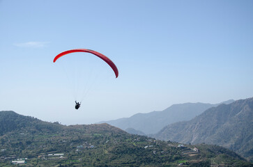 Paragliding in the sky. Flying over mountains, Extreme sport in mountain with nature, High-Flying Adventure, Uttarakhand, India.