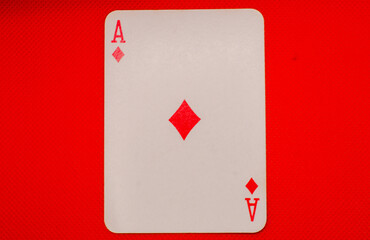 Obraz premium ace of diamonds on a red background.