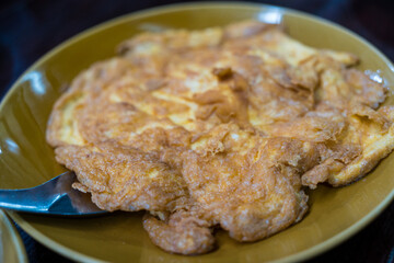 Yellow omelet with spoon is another simple dish in Thailand.
