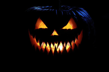 Naklejka premium Fanged jack-o'-lantern isolated in the dark.
