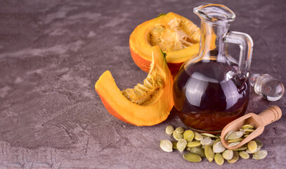 Pumpkin seed oil in a decanter on a gray background. Copy space.

