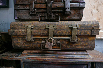 A pile of ancient, rusty suitcases complete with locks and latches that are still locked.