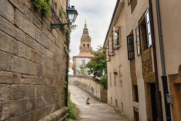 Fototapeta premium Tourist woman walking through the narrow streets of the historic center of Santiago de Compestela, Galicia.
