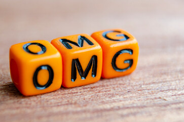 OMG text represent Oh My Gosh on wooden table